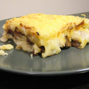 Une portion de hachis parmentier sur une assiette gris taupe